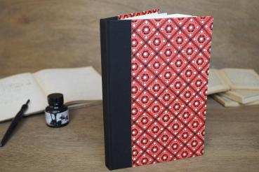 notizbuch, hardcover mit schwarzem Leinenrücken, rotes Bezugspapier mit schwarz-weißem geometrischen Muster